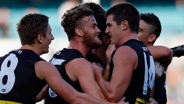 John McCarthy (second from left) celebrates a Port Adelaide goal with his new teammates this year.