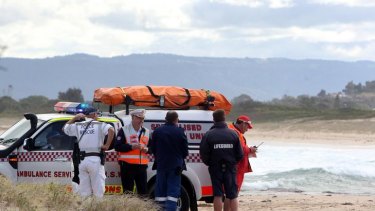 Police and rescue workers attend to the scene at Windang Island, where a man drowned.