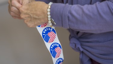 A voter peals off an "I Voted" sticker at a polling location in Larkspur, California.