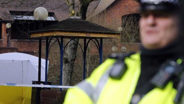 A police officer secures the area where Skripal and his daughter were found critically ill on the park bench.