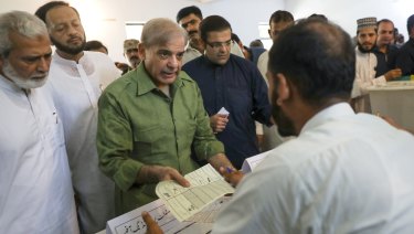 Shehbaz Sharif, president of the Pakistan Muslim League-Nawaz, receives his ballot at a polling station in Lahore.