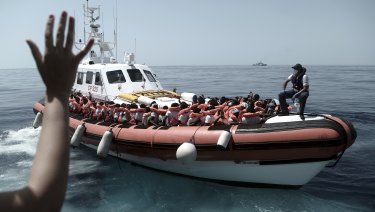 Migrants board an Italian Coast Guard ship after being transferred from the Aquarius to be taken to Spain on Tuesday.