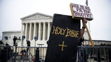 A protester dressed as the Holy Bible rallies against Masterpiece Cakeshop owner Jack Phillips outside the Supreme Court in Washington.