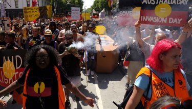 Protesters carry a coffin down Bourke Street.