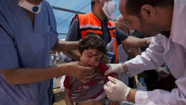 Medics treat a Palestinian child suffering from teargas inhalation during a protest near Beit Lahiya, Gaza Strip, on Monday.