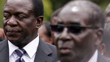 Then vice-president Emmerson Mnangagwa, left, stands behind his then president Robert Mugabe in 2014.