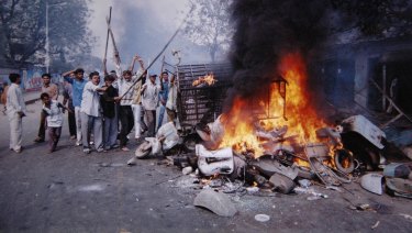 A mob sets fire to vehicles and other goods in Ahmadabad, India in 2002. Sectarian violence erupted as retaliation after 59 Hindus were killed when a train car burst into flames in Godhra.