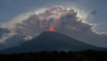 Mount Agung's crater glows red from the lava.