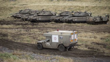 An Israeli military ambulance drives past tanks in the Israeli-controlled Golan Heights, near the border with Syria.