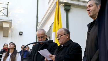 Archbishop Charles Scicluna, holding paper, Spanish Monsignor Jordi Bertomeu, right, and Papal Nuncio Ivo Scapolo, left, give a press conference in Santiago, Chile.