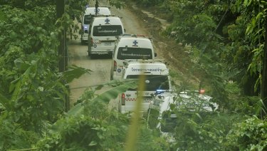 Five ambulances drive up the road leading to Tham Luang cave during the rescue operation. 