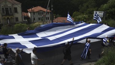 Opponents of the deal between Greece and Macedonia on the latter country's new name 'North Macedonia' carry a huge Greek flag at the village of Pisoderi near the border with Macedonia in northern Greece in June.