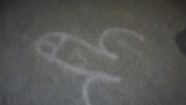 An image of a giant phallus spraypainted on the carpet. 
