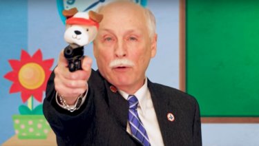 Philip Van Cleave, president of the Virginia Citizens Defence League, explains the use of 'Puppy Pistol' to children in a satirical video orchestrated by Sacha Baron Cohen.