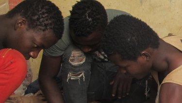 Teen migrants rest in a compound in Agadez, Niger, in December.
