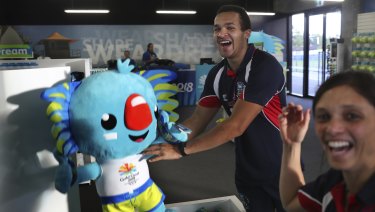 Athletes from the Falkland Islands play with Commonwealth Games mascot Borobi in the Games village.