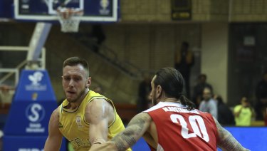 Australia's Mitch Creek drives to the basket, while Iran's Michael Rostampour defends.