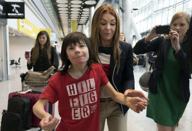 Charlotte Caldwell and her son Billy walk through Heathrow Airport.