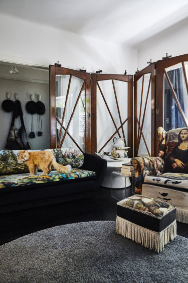 Harvey on a vintage sofa reupholstered by Suzie Stanford. The screen panel is made from salvaged doors and the porcelain sculpture is by Paul Wood.