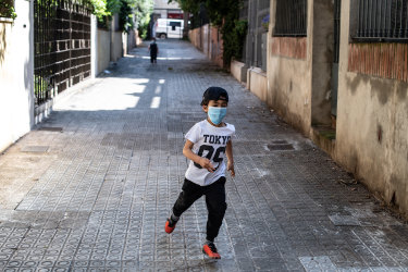 Toni Roses runs on the street outside his house in Barcelona, Spain. 