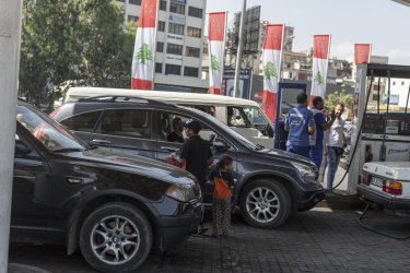 Children try to sell tissues to motorists who had been queuing for hours to fill up due to fuel shortages. 