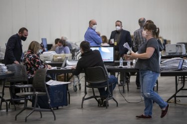 Election officials, poll watchers and challengers monitor the counting of Grand Rapids absentee ballots in Michigan