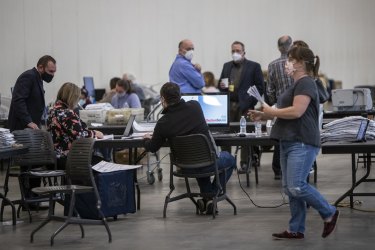 Election officials, poll watchers and challengers monitor the counting of Grand Rapids absentee ballots in Michigan.