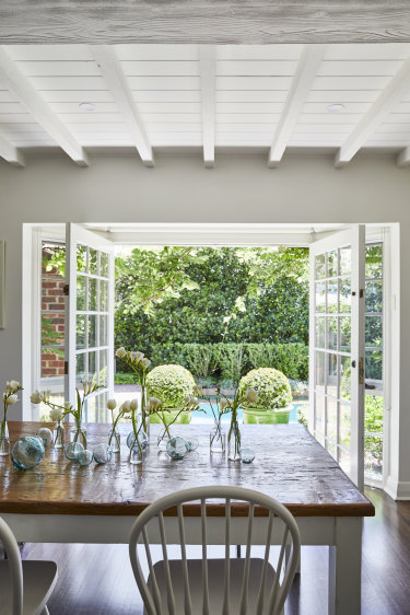 French doors open from the dining room to the pool and the traditional English-style garden lined with bay laurel, murraya and thyme hedges.
