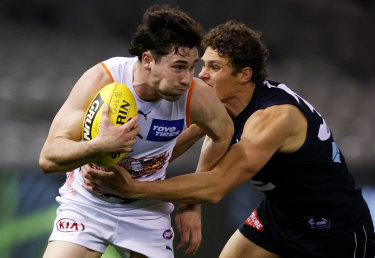 Lachie Ash is tackled by Charlie Curnow during Saturdayâ€™s clash. 