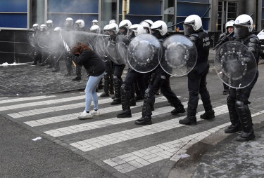 A police officer sprays pepper spray during a protest against coronavirus measures in Brussels.