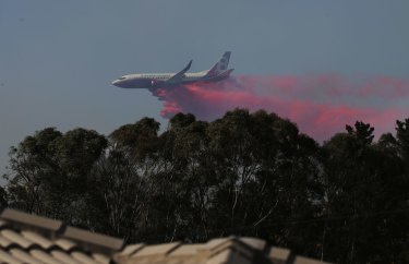 Water bombing aircraft works to save homes at Greta.