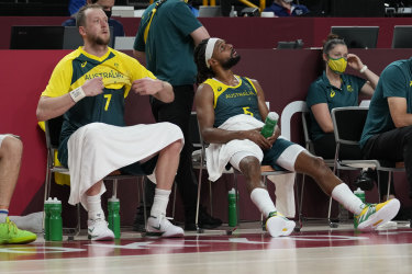 Matthew Dellavedova, Joe Ingles and Patty Mills sit on the bench in the final minutes.