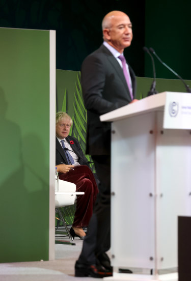 British Prime Minister Boris Johnson seated onstage as he listens to Jeff Bezos speak during an Action on Forests and Land Use event.