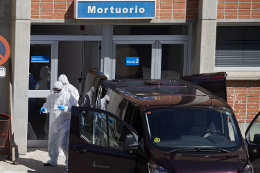 Workers transport a corpse from the mortuary of the Severo Ochoa Hospital on March 28, 2020 in Madrid, Spain.