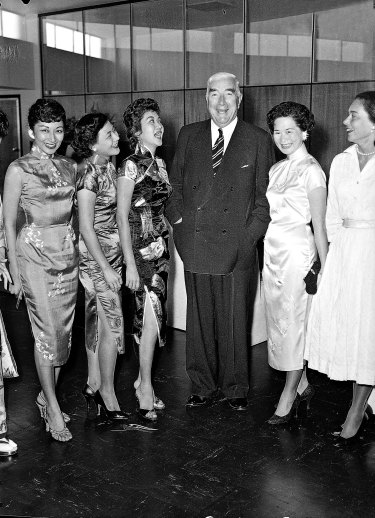 The Prime Minister with ground hostesses at the opening of the Qantas building on October 28, 1957. 