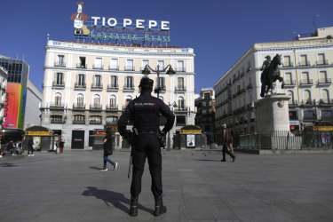 A police officer stands guard at Sol square in downtown Madrid.