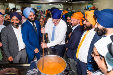 Prime Minister Scott Morrison stirs a curry.