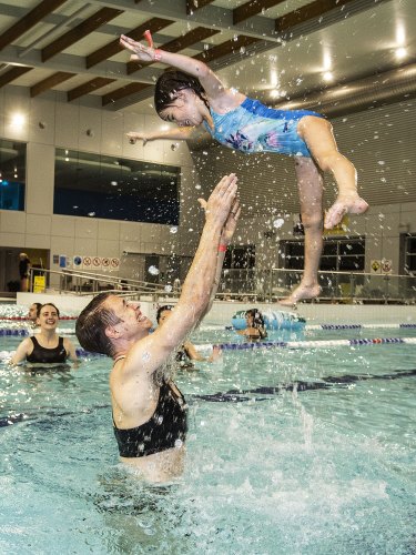 Non-binary person Chris and their child make a splash at Ashfield Aquatic Centre.
