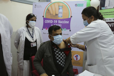 An Indian doctor receives a COVID-19 vaccine at a government Hospital in Jammu, India.
