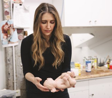 Patricia Piccinini holding one of her silicone sculptures. 