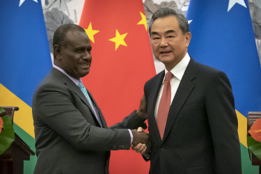 Solomon Islands Foreign Minister Jeremiah Manele, left, and Chinese Foreign Minister Wang Yi shake hands during a ceremony to mark the establishment of diplomatic relations between Solomon Islands and China.