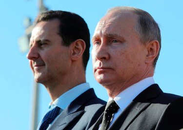 Russian President Vladimir Putin, right, and Syrian President Bashar Assad watch troops marching at the Hemeimeem air base in Syria in 2017.