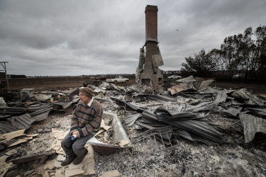 Angus McGillivery sits in the ruins of his Coyles Road home near Terang. 