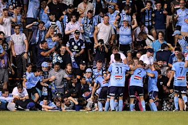 Fall season: Sydney fans sprawl onto the turf after the fence collapsed during celebrations for Cam Devlin's late sealer.