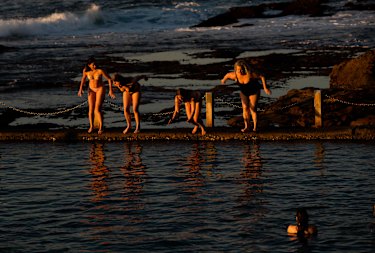 After viewing the sunrise,  a group of swimmers dive into Mahon Pool at Maroubra, on the last day of winter, in Sydney. 