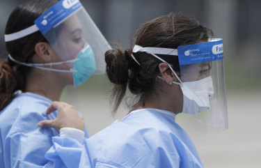Healthcare workers at a COVID-19 testing site in Florida as cases surge.