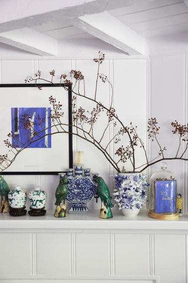 “The mantel in the sitting room holds cherished wedding gifts and travel mementos from Shanghai and Tulum.” The artwork is by Katherine Hattam.