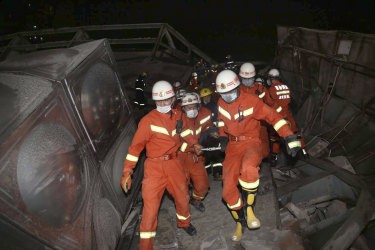 Rescuers evacuate an injured person from the rubble of a collapsed hotel building in Quanzhou city. 