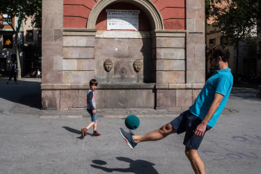 A father and his son play football in Barcelona, Spain.