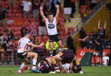 Bronco buster: Luke Brooks jumps for joy as Michael Chee Cam scores his match-winning try.